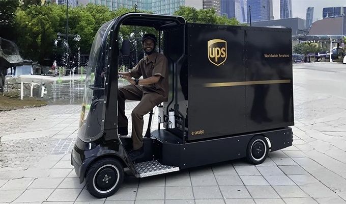 Elektrisch UPS-bezorgvoertuig met chauffeur op een stadsplein